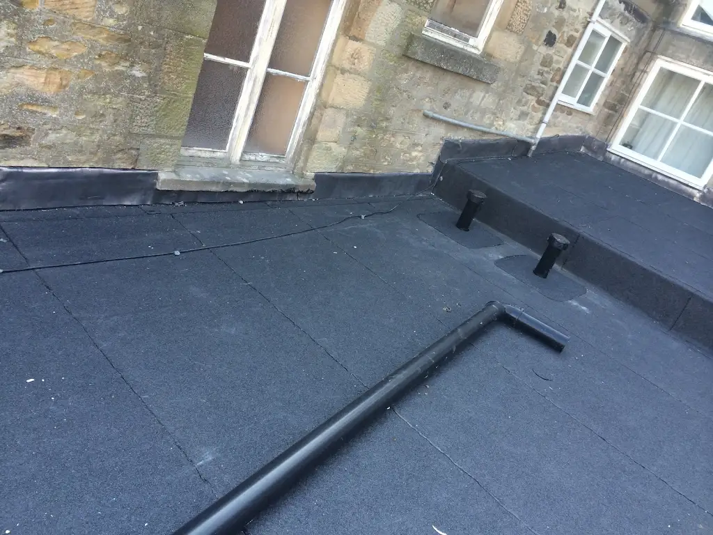 Completed flat roof with felt membrane and lead flashing